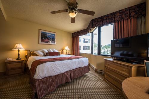 a hotel room with a bed and a flat screen tv at The Grand Lodge Hotel and Suites in Mount Crested Butte
