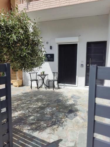 a patio with two chairs and a table in front of a building at ISMINI STUDIOS in Menídion