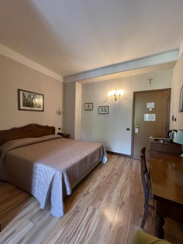 a bedroom with a bed and a dresser and a desk at Hotel La Torre in Castiglione dʼIntelvi