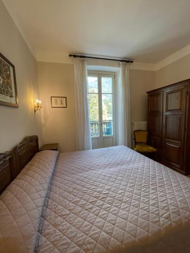 a bedroom with a large bed and a window at Hotel La Torre in Castiglione dʼIntelvi