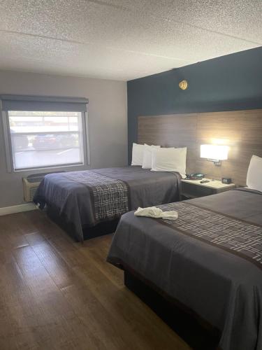 a hotel room with two beds and a window at Days Inn by Wyndham Orange City/Deland in Orange City