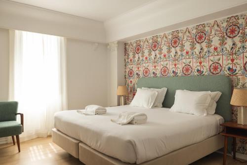 カスカイスにあるPergola Boutique Hotelのベッドルーム1室(大型ベッド1台、タオル2枚付)