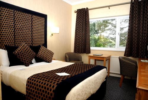 a hotel room with a bed and a window at Carlton Park Hotel Rotherham in Rotherham