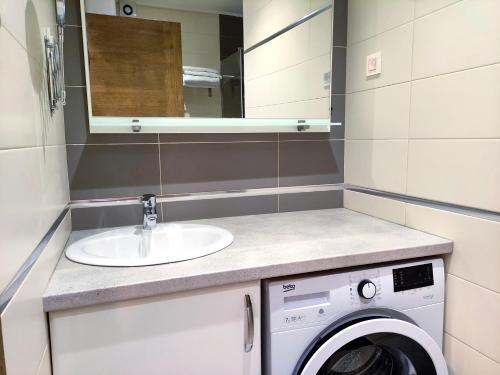 a bathroom with a sink and a washing machine at Nature Escape Amazing Sea View in Budva