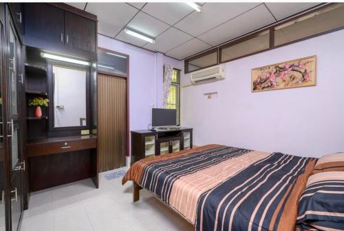 a bedroom with a bed and a television in it at Lotus House in Ban Lo Long