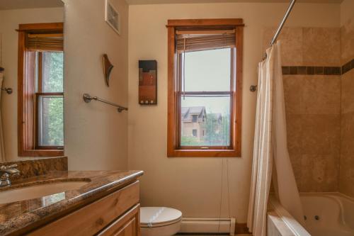 a bathroom with a sink and a toilet and a window at Antlers Gulch 501 in Keystone