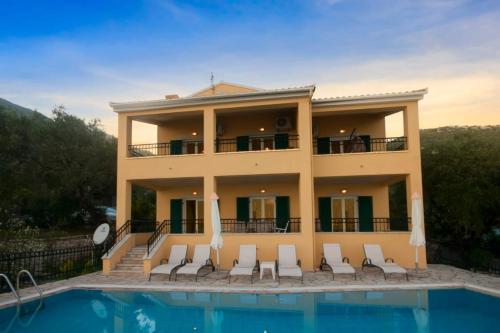 une grande maison avec une piscine en face de celle-ci dans l'établissement Villa Spyros, à Nisakion