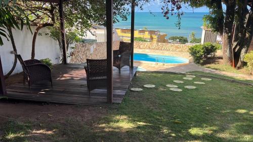 une terrasse en bois avec des chaises et une piscine dans l'établissement Sezimbra village flat, à Natal