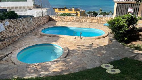 - une piscine dans une arrière-cour avec un mur en briques dans l'établissement Sezimbra village flat, à Natal