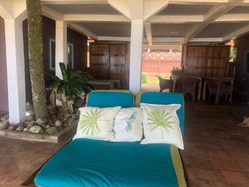 a blue couch with four pillows on a porch at 'Crows Nest' Studio Apt. in Big Corn Island