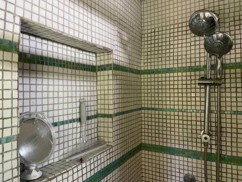 a tiled bathroom with a urinal and a mirror at 'Crows Nest' Studio Apt. in Big Corn Island