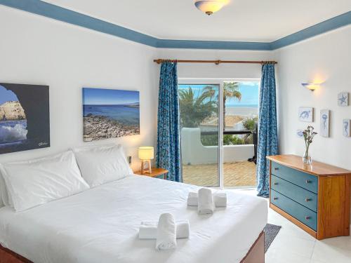 - une chambre avec un lit et une vue sur la plage dans l'établissement Lovely Apartment in Albufeira 2BD 250m Beach Ocean view and AC Wi-Fi Pool, à Albufeira