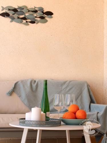 a table with a bottle and glasses and oranges on it at Flamenco Ambar Luxury Apartment 15 Planta in Calpe