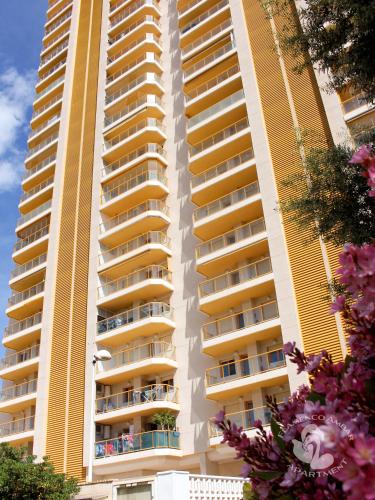 a tall apartment building with pink flowers in front of it at Flamenco Ambar Luxury Apartment 15 Planta in Calpe