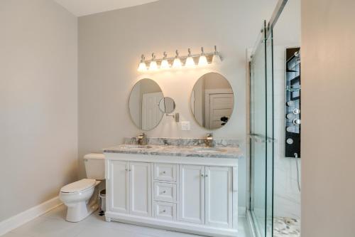 a bathroom with a toilet and a sink and mirror at Spacious Chicago Condo with Deck Less Than 9 Mi to Downtown! in Oak Park