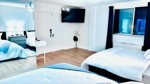 a bedroom with two beds and a tv and a mirror at Highrise luxury two bedroom condo in Downtown Atlanta within minutes!! in Atlanta