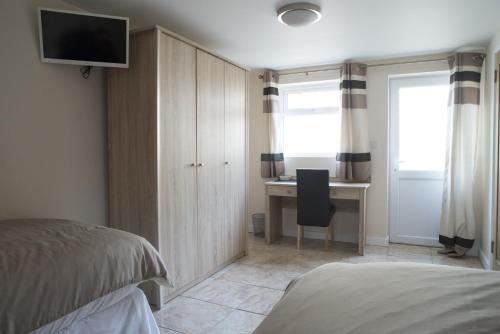 a bedroom with a bed and a desk with a television at The Bell P.H. in Brandon