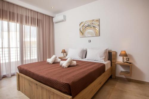 a bedroom with a large bed and a window at M&E APARTMENTS in Haraki