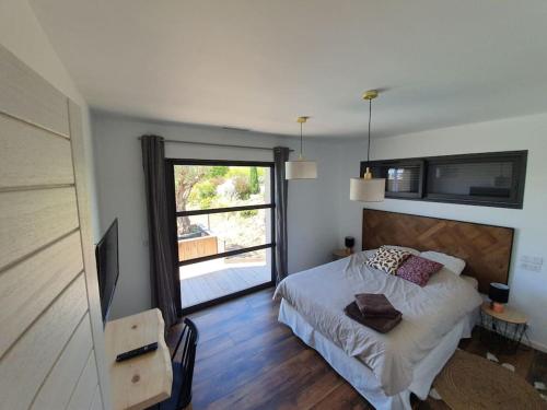 ein Schlafzimmer mit einem Bett und einem großen Fenster in der Unterkunft Villa Onda piscine chauffée 3 ch plage 1 km de la plage in Lecci