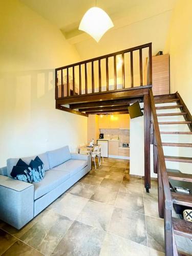 a living room with a blue couch and a staircase at Elegant modern loft in Kryopigi in Kriopigi
