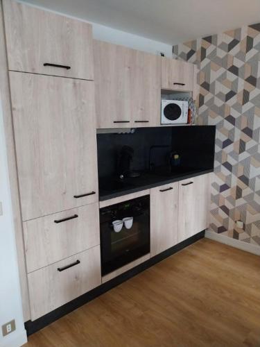 uma cozinha com armários brancos e um micro-ondas em f2 gerardmer em Gérardmer