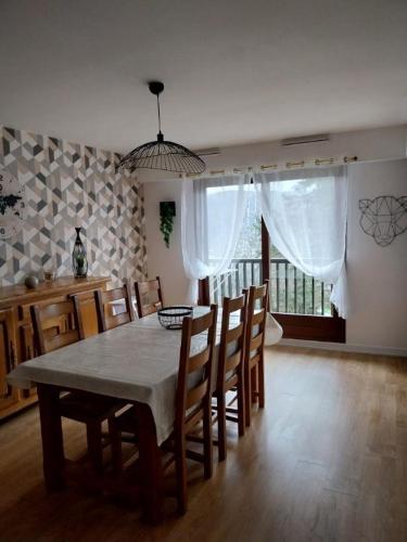 uma sala de jantar com uma mesa e cadeiras e uma janela em f2 gerardmer em Gérardmer