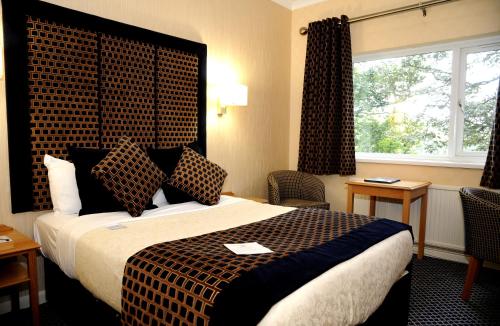 a hotel room with a large bed and a window at Carlton Park Hotel Rotherham in Rotherham
