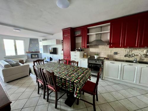 una cucina con armadi rossi e un tavolo con sedie di Casa Sancio a Spotorno