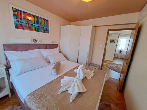 Un dormitorio con una cama blanca con toallas. en Apartment Bella Sanja, en Split