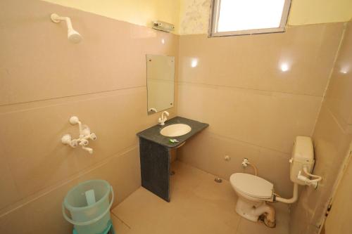 a bathroom with a toilet and a sink and a mirror at Hotel Mukund Priya- Near Krishna Janam Bhoomi in Mathura