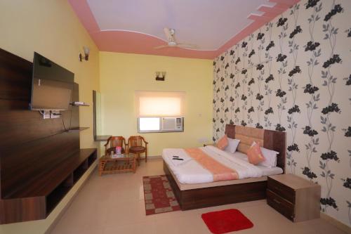 um quarto com uma cama e uma televisão num quarto em Hotel Mukund Priya- Near Krishna Janam Bhoomi em Mathura