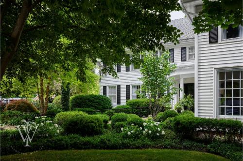 a white house with a garden in front of it at Wickwood Inn in Saugatuck