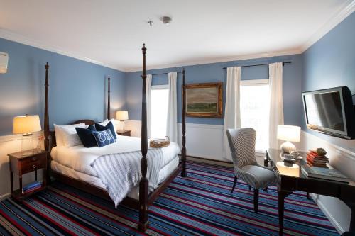 a bedroom with a bed and a desk and a television at Kennebunkport Inn in Kennebunkport