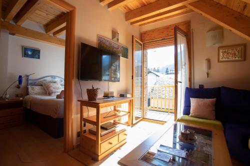um quarto com uma cama, uma televisão e um sofá em Apartamento con Encanto em Vielha