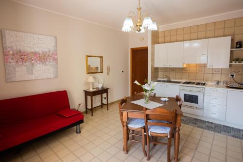 ein Wohnzimmer mit einem Tisch und einem roten Sofa in der Unterkunft Gilda’s Home in Scalea