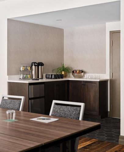 a kitchen with a wooden table and chairs and a counter at The Metcalfe by Gray Collection in Ottawa