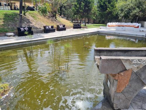 a fountain in a pond in a park at Hotel Rio Atlixco in Atlixco