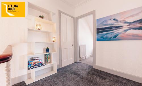 a hallway with white shelves and a painting on the wall at Stylish Central Eden Cottage with Courtyard & Free Parking in Dundee
