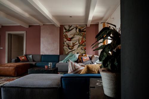 a living room with a blue couch and a plant at SintPieter17 Lo-Ghis vakantiewoning in Voeren