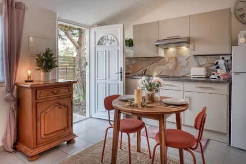 a kitchen with a wooden table and chairs and a table at Cottage Au Coin du Feu in Rambouillet
