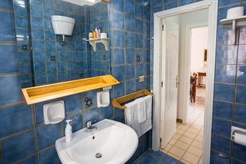 uma casa de banho com um lavatório e uma parede de azulejos azuis em Gilda’s Home em Scalea