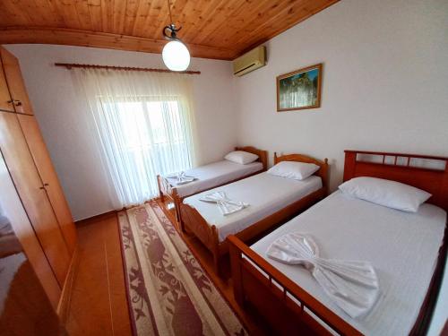a room with two beds and a window at Sokolli Guest House in Gjirokastër
