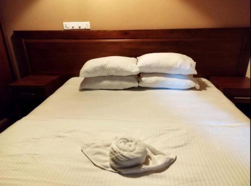 Sombrero en la parte superior de una cama con almohadas en Charming Daisy, en Naifaru