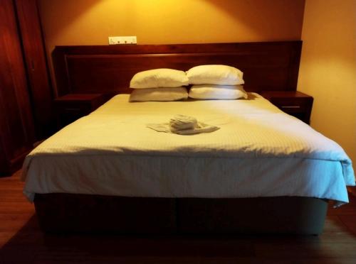 1 dormitorio con 1 cama con sombrero en Charming Daisy, en Naifaru