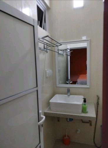 W łazience znajduje się umywalka i lustro. w obiekcie Charming Daisy w mieście Naifaru