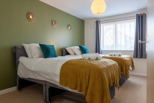 a bedroom with two beds with blankets on them at Stylish 2 bedroom, 2 bathroom with Sky TV, Free Parking and WiFi By HP Accommodation in Milton Keynes