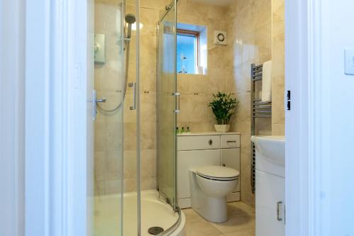 a bathroom with a shower and a toilet and a sink at Stylish 2 bedroom, 2 bathroom with Sky TV, Free Parking and WiFi By HP Accommodation in Milton Keynes