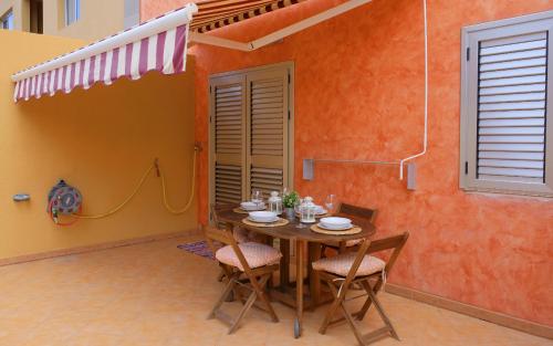 坎德拉里亞的住宿－EDEN RENTALS Caletillas Peace，橙色墙壁的房间里摆放着桌椅