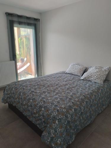 1 dormitorio con 1 cama grande con almohadas y ventana en T2 Embrun vu les Orres en Embrun