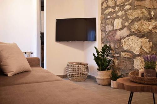 a living room with a couch and a stone wall at Hemeros Villa in Zefiría